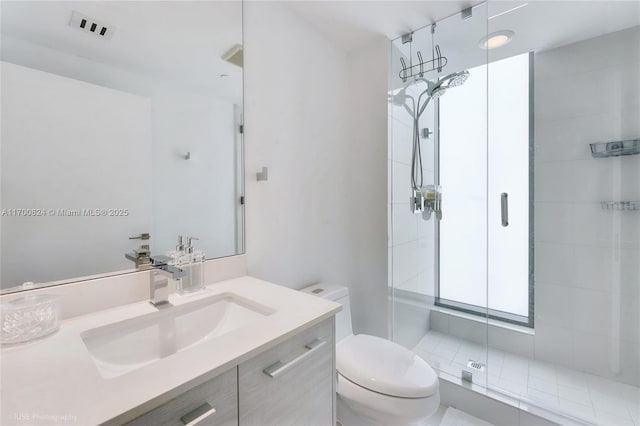 full bath with a shower stall, vanity, visible vents, and toilet