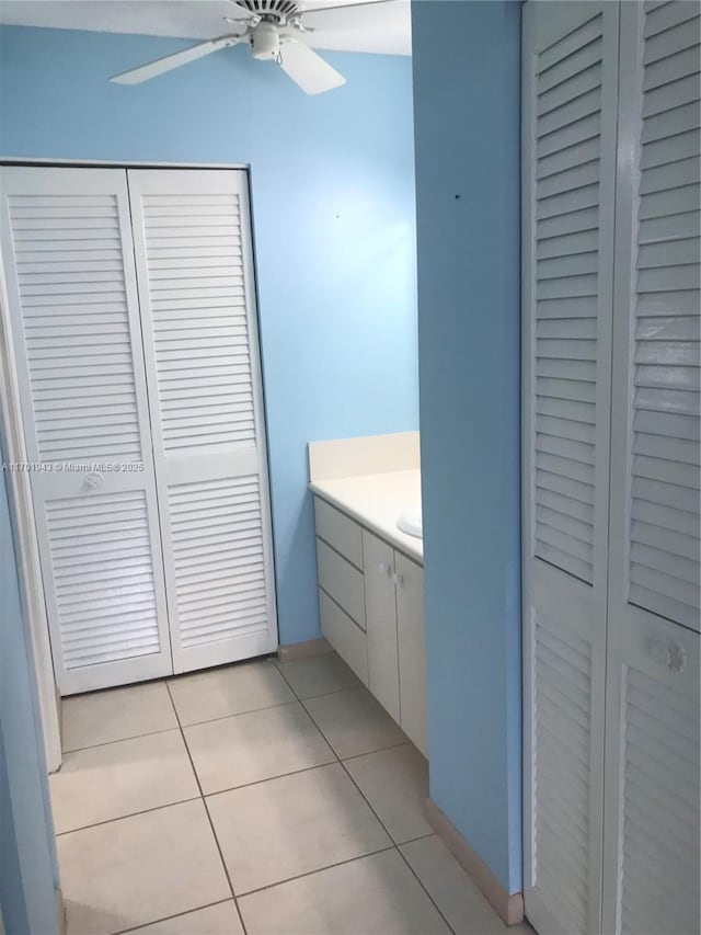 bathroom with tile patterned flooring, ceiling fan, a closet, and vanity