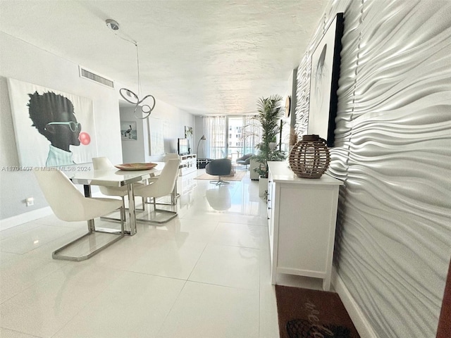 dining space featuring light tile patterned floors and a textured ceiling