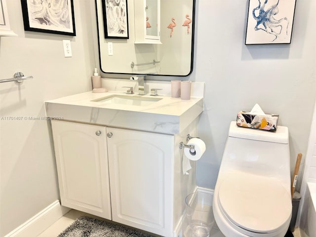 bathroom with tile patterned flooring, vanity, and toilet