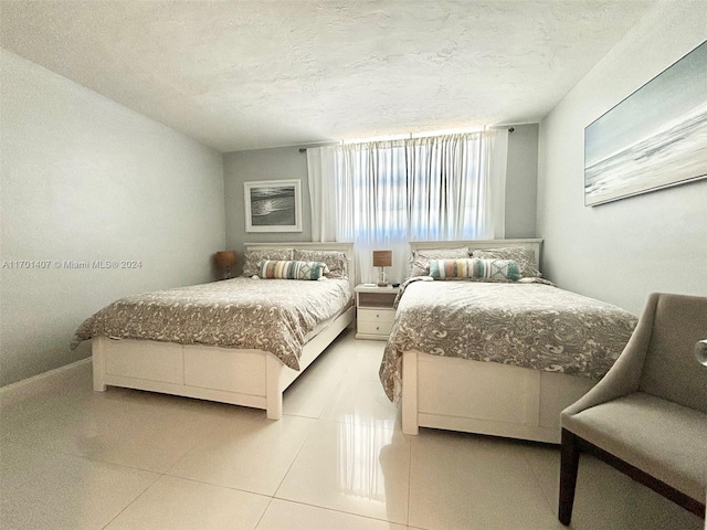 tiled bedroom featuring a textured ceiling