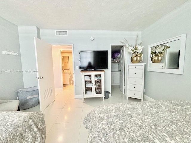 bedroom with light tile patterned flooring and a textured ceiling