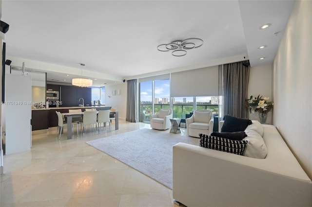 living room with floor to ceiling windows, sink, and an inviting chandelier