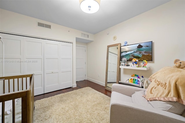 bedroom featuring dark wood-type flooring and a closet