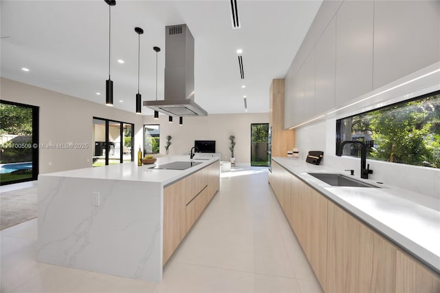 kitchen with sink, light brown cabinets, pendant lighting, island exhaust hood, and a large island