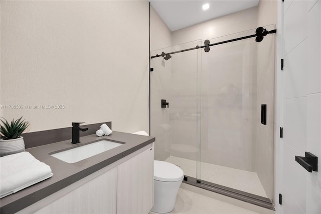 bathroom featuring vanity, toilet, and a shower with shower door