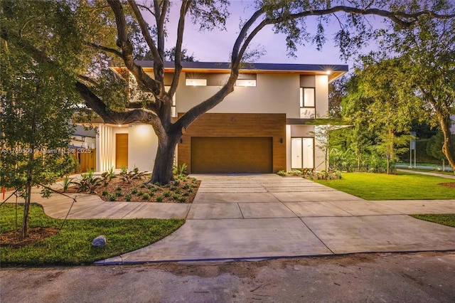 modern home featuring a garage and a lawn