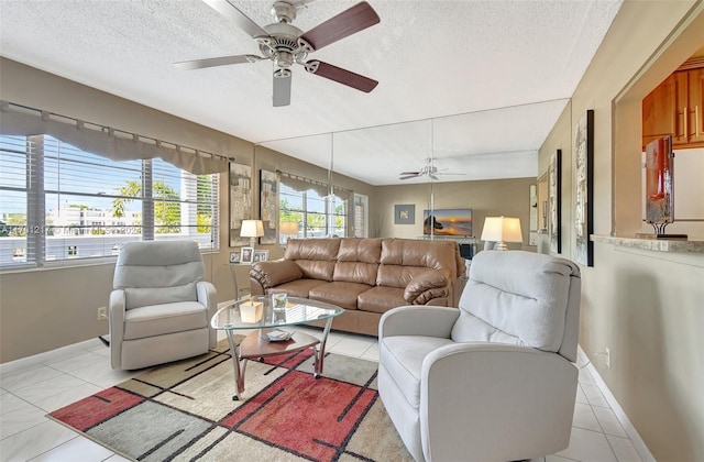 tiled living room with ceiling fan and a textured ceiling