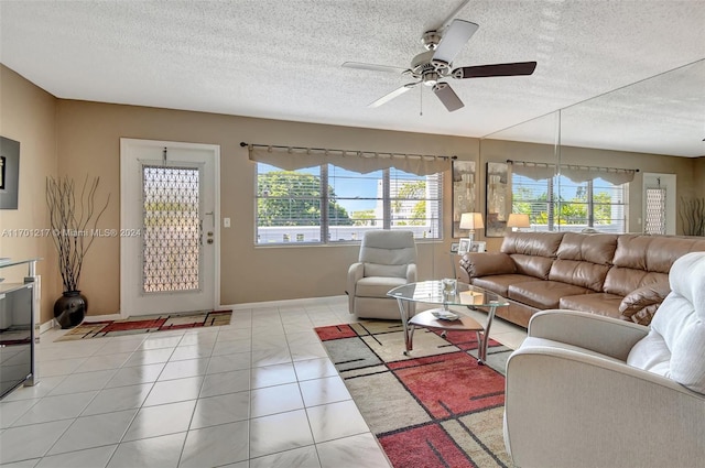 tiled living room with ceiling fan and a textured ceiling