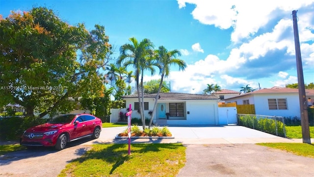 view of front of property featuring concrete driveway and fence