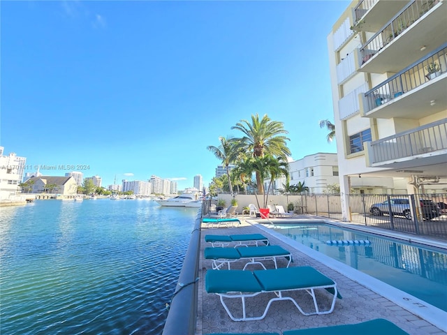 view of swimming pool featuring a patio area and a water view