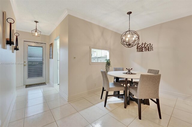 tiled dining room with a textured ceiling and a notable chandelier