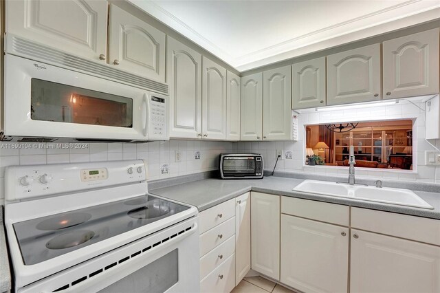 kitchen featuring light tile patterned flooring, white appliances, sink, and tasteful backsplash