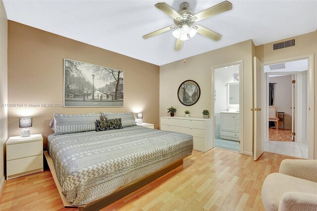 bedroom featuring hardwood / wood-style flooring, ceiling fan, and ensuite bathroom