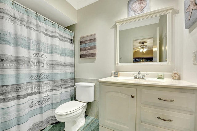 bathroom with vanity, tile patterned flooring, ceiling fan, toilet, and tile walls