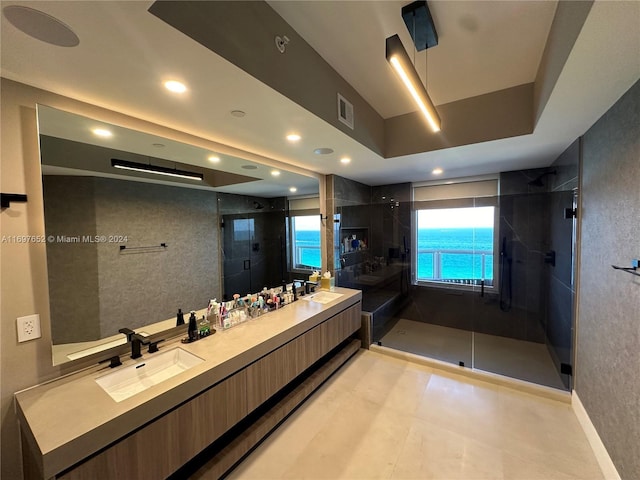 bathroom featuring vanity, a water view, and an enclosed shower