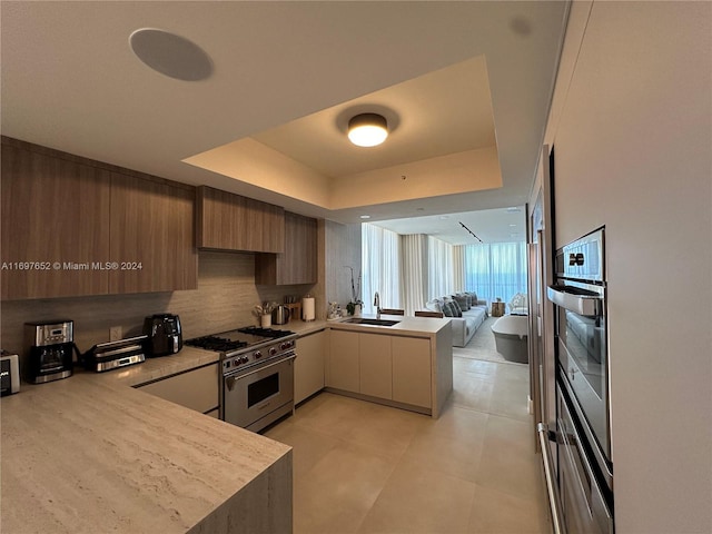 17875 Collins Ave Unit 1801, Sunny Isles Beach, FL 33160 - kitchen with appliances with stainless steel finishes, a peninsula, light countertops, open floor plan, and a raised ceiling