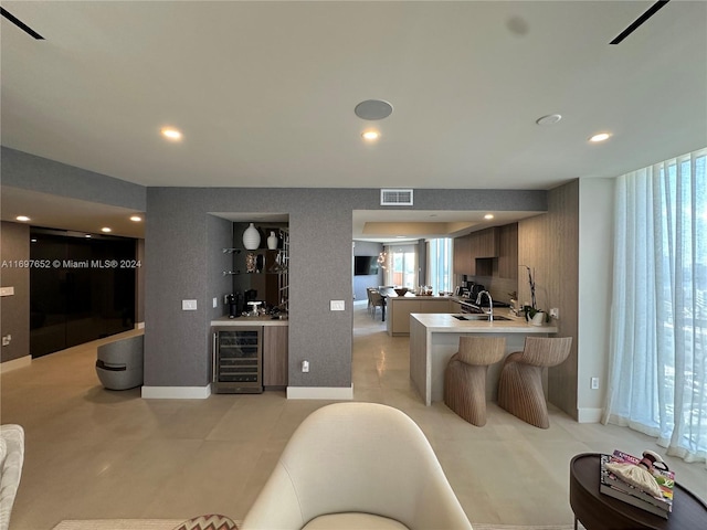 17875 Collins Ave Unit 1801, Sunny Isles Beach, FL 33160 - kitchen featuring beverage cooler, a breakfast bar area, a peninsula, healthy amount of natural light, and recessed lighting