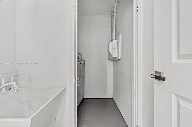 bathroom featuring electric water heater, sink, and concrete floors