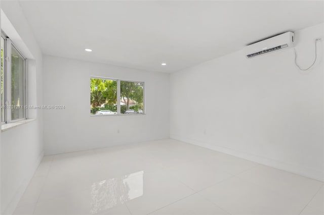 empty room with light tile patterned flooring and a wall unit AC