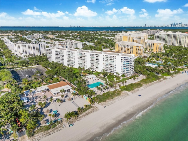 birds eye view of property with a water view and a beach view