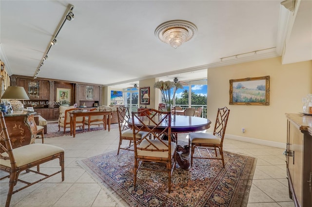 605 Ocean Dr Unit 4L, Key Biscayne, FL 33149 - dining space featuring rail lighting, light tile patterned flooring, ornamental molding, and baseboards