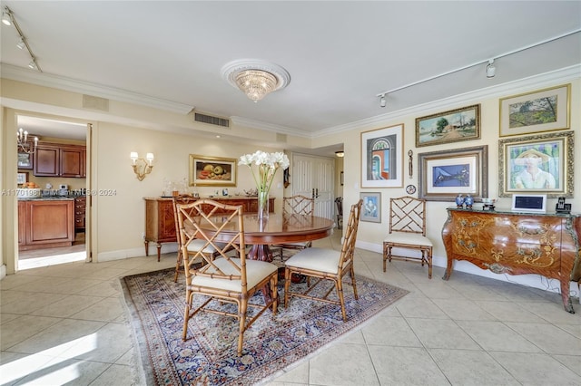 tiled dining room with rail lighting and ornamental molding