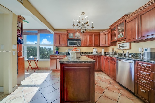 kitchen with sink, a center island, light tile patterned flooring, and appliances with stainless steel finishes