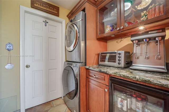 washroom with light tile patterned floors, wine cooler, and stacked washer and clothes dryer