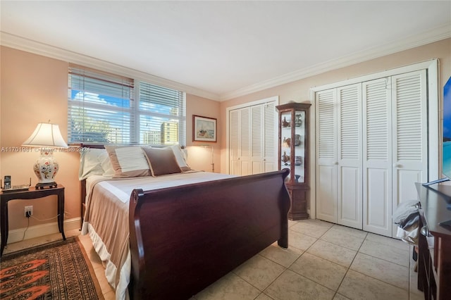 tiled bedroom featuring two closets and ornamental molding