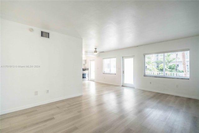 unfurnished living room featuring ceiling fan and light wood-type flooring