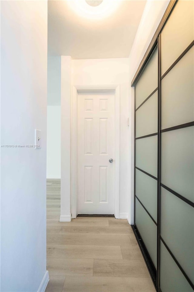 hallway with light hardwood / wood-style floors