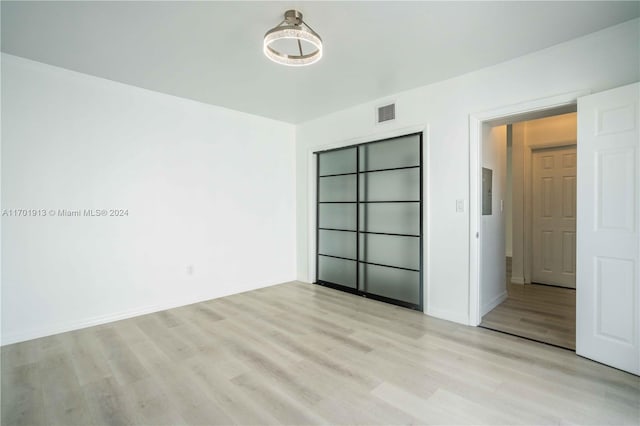 unfurnished bedroom featuring a closet and light hardwood / wood-style floors