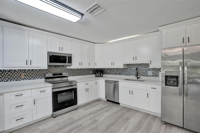 kitchen with sink, white cabinets, and appliances with stainless steel finishes