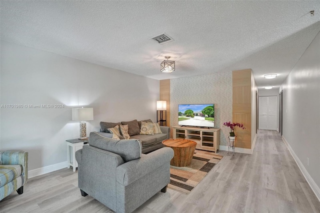 living room featuring a textured ceiling and light hardwood / wood-style flooring