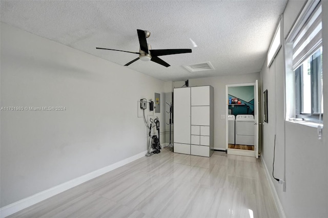 unfurnished room with washing machine and clothes dryer, ceiling fan, light hardwood / wood-style floors, and a textured ceiling