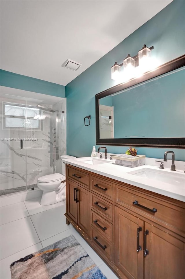 bathroom featuring tile patterned flooring, vanity, a shower with door, and toilet