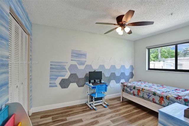 bedroom with wood-type flooring, a textured ceiling, a closet, and ceiling fan