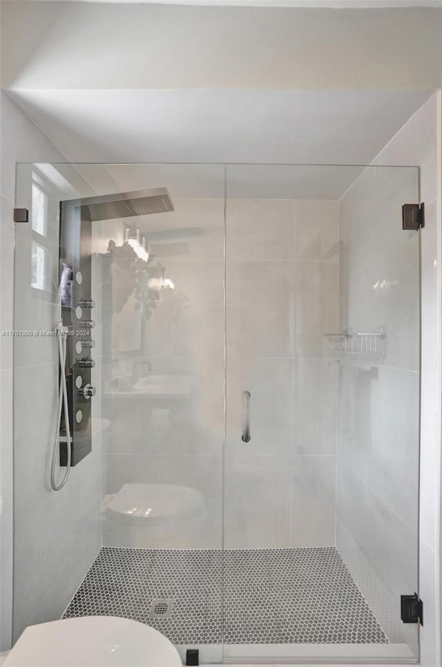 bathroom featuring toilet and a shower with shower door