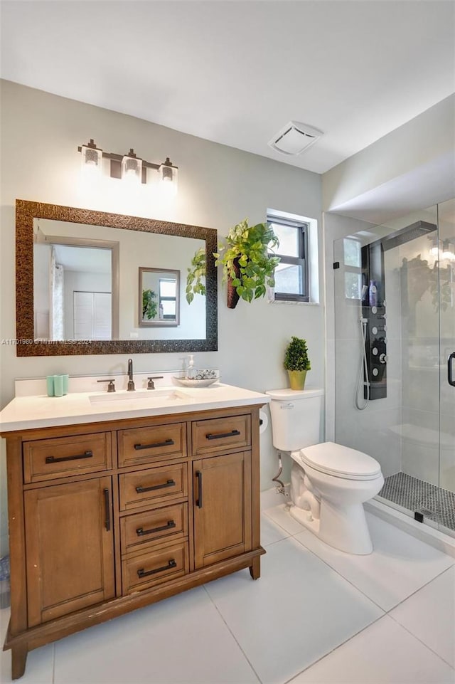 bathroom featuring tile patterned flooring, vanity, a shower with door, and toilet