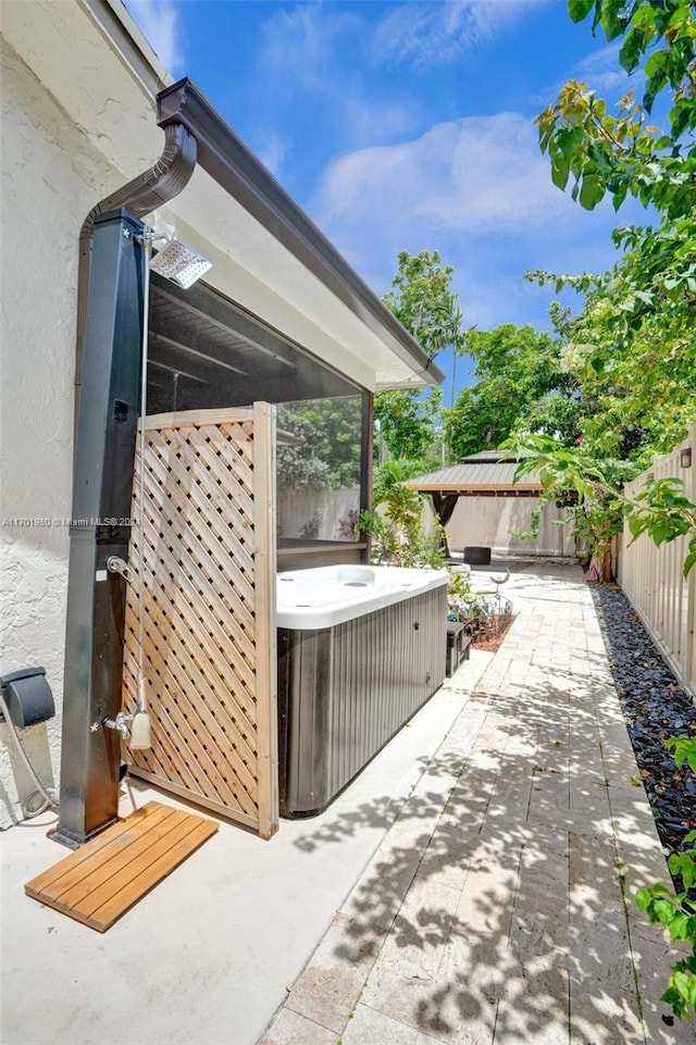 view of patio with central air condition unit and a hot tub