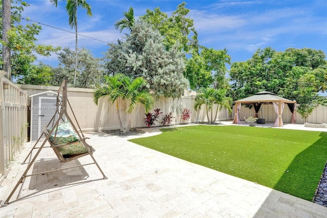 view of yard with a gazebo, a patio, and a storage unit