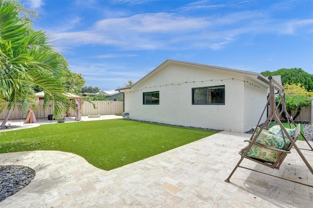 back of property with a patio area and a yard