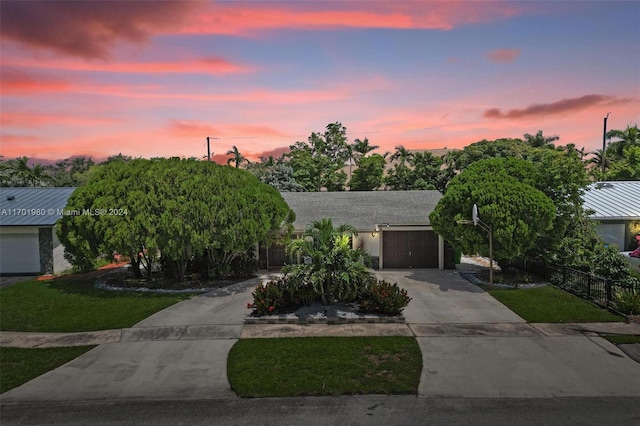 view of front of home featuring a garage and a lawn