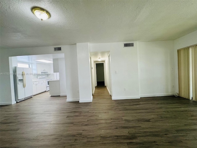 unfurnished living room with a textured ceiling and dark hardwood / wood-style flooring