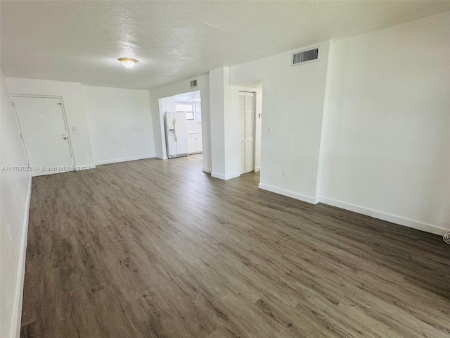 unfurnished room with dark hardwood / wood-style floors and a textured ceiling