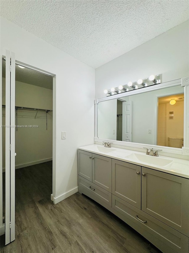 bathroom featuring hardwood / wood-style floors, vanity, and a textured ceiling