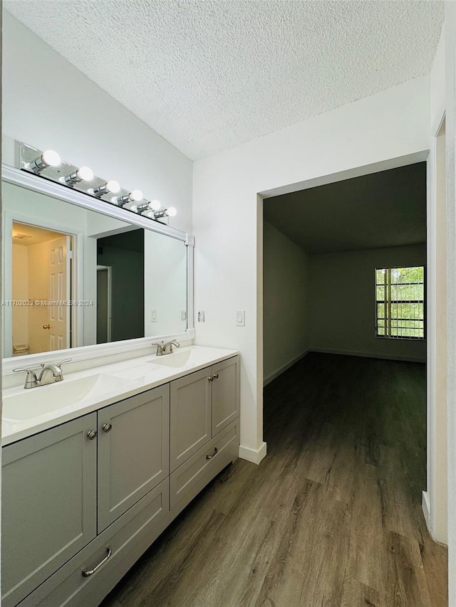 bathroom with hardwood / wood-style floors, vanity, and a textured ceiling