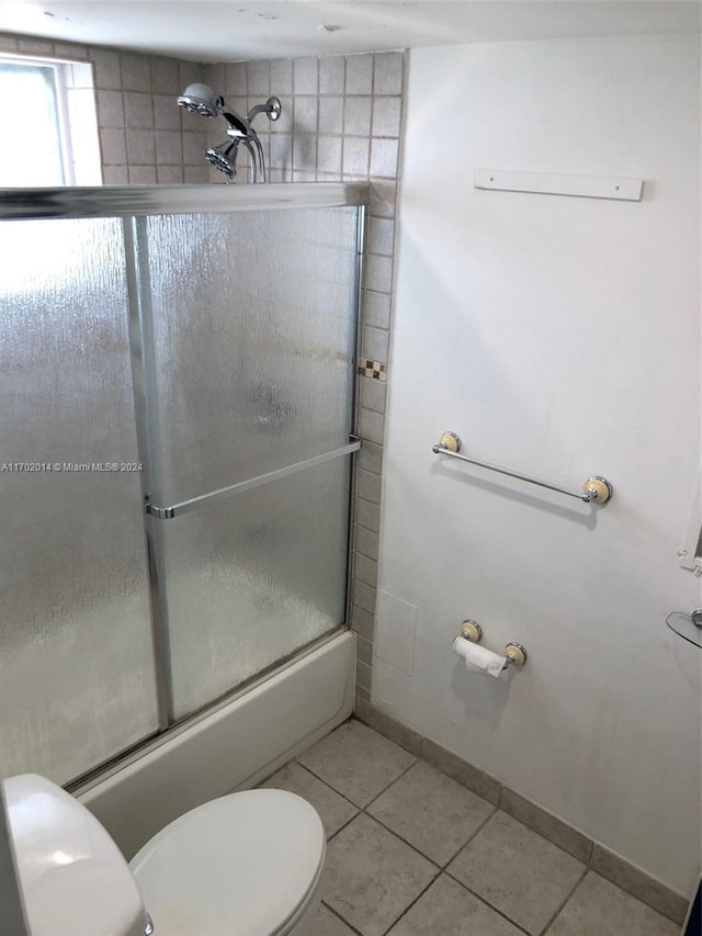 bathroom with shower / bath combination with glass door, tile patterned floors, and toilet