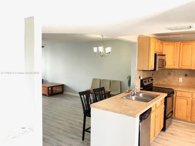 kitchen with sink, light wood-type flooring, light brown cabinets, and appliances with stainless steel finishes